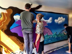 young people painting wall art