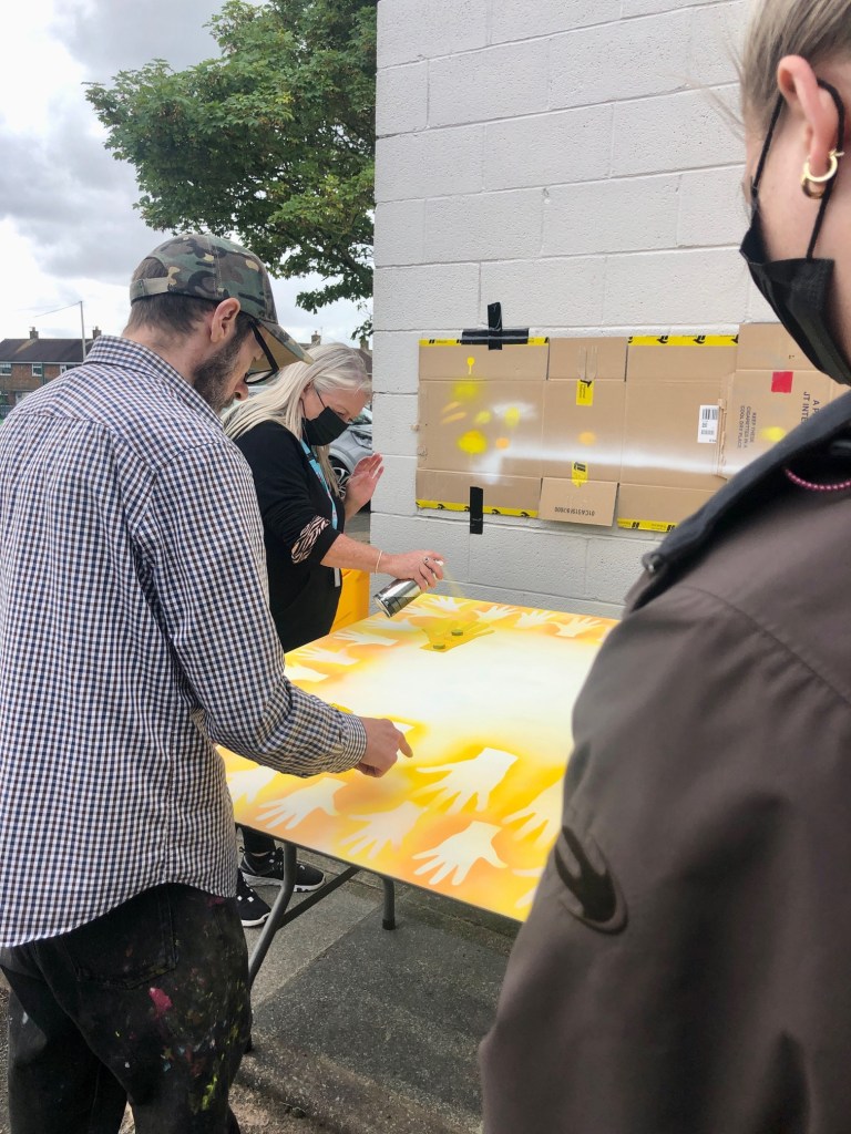 hands spray painted on to community sign
