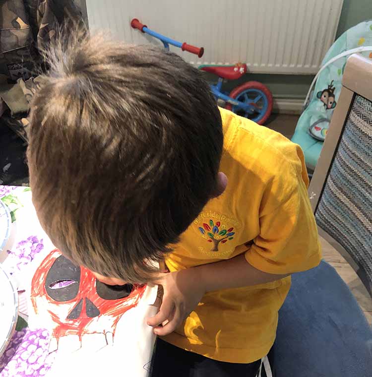 coloring in a red skeleton mask for Halloween on my own